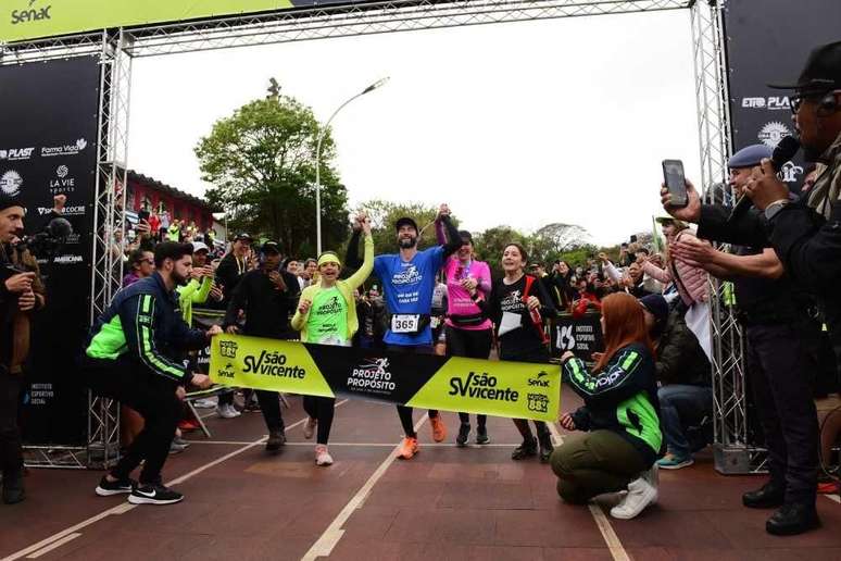 Hugo cruzando a linha de chegada da maratona 366 ao lado de sua fam&iacute;lia