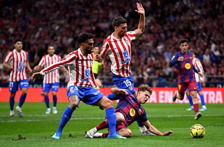 Fermin Lopez (no ch&atilde;o) recebe a marca&ccedil;&atilde;o dos atleticanos Nicolas Gonzalez e&nbsp; Lenglet