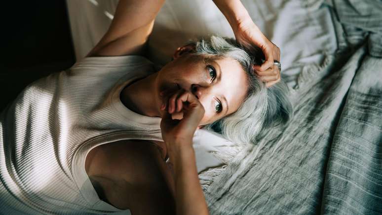 பெண் படுக்கையில் படுத்திருக்கிறாள், விழித்திருக்கிறாள்