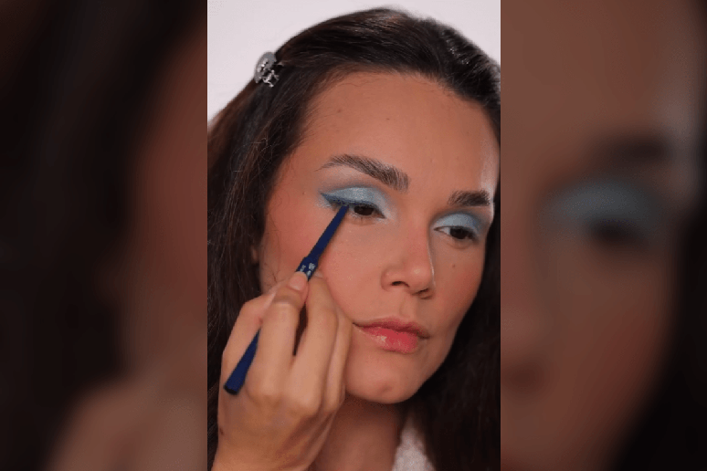 A sombra azul rente aos c&iacute;lios inferiores intensifica o olhar, e o l&aacute;pis no mesmo tom na linha d&rsquo;&aacute;gua refor&ccedil;a o destaque 