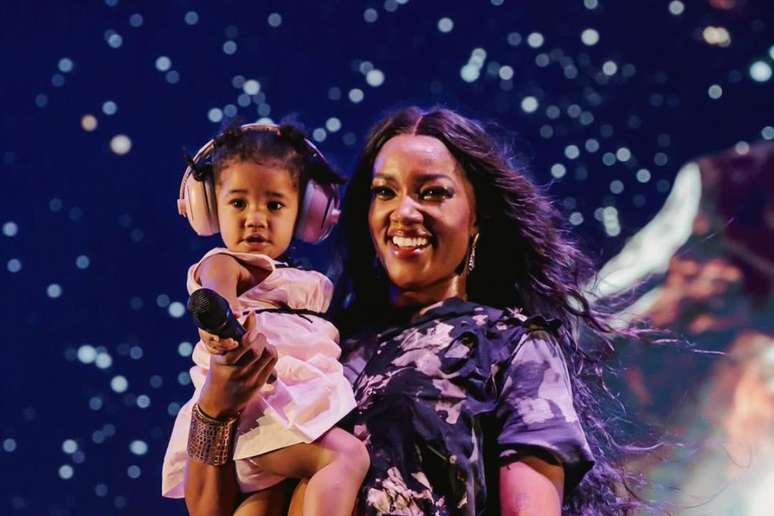 Nala sendo segurada por Iza durante show