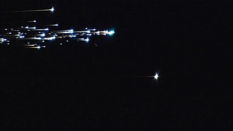 Um rastro de luzes brilhantes contra um fundo preto.