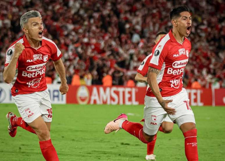 O zagueiro Olivera corre para comemorar o gol do Santa Fe .