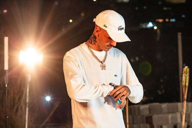 DJ Gu வெள்ளை நிற தோற்றம் மற்றும் அணிகலன்களுடன் புகைப்படத்திற்கு போஸ் கொடுக்கிறார்