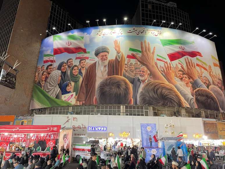 Um grande mural retratando o falecido aiatol&aacute; Ali Khamenei est&aacute; pendurado em uma movimentada rua comercial.