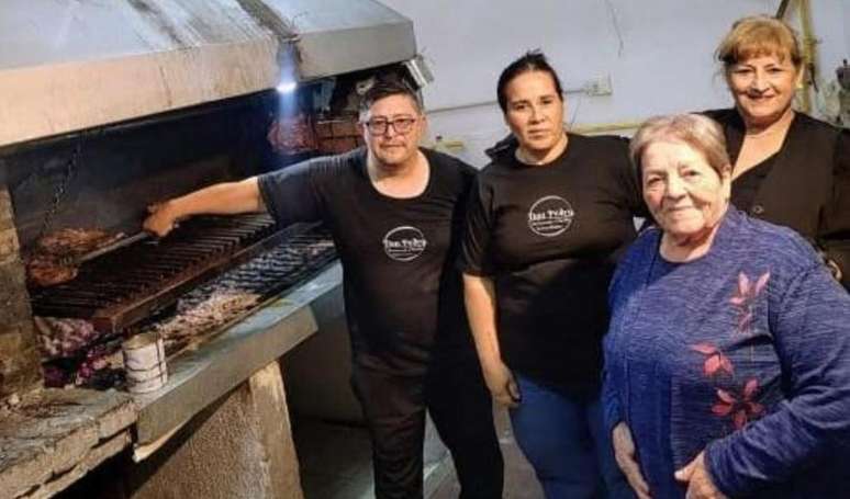 Carla Gutierrez (de cabelo preto amarrado) e sua m&atilde;e ao lado de funcionários no restaurante Don Pedro