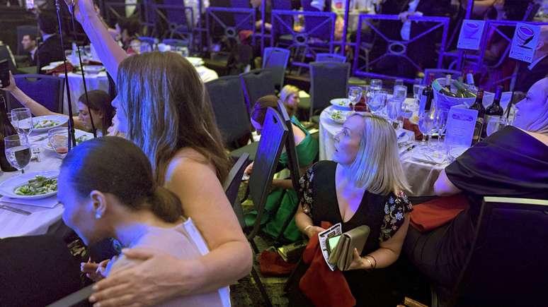 Pessoas se abaixam durante o jantar