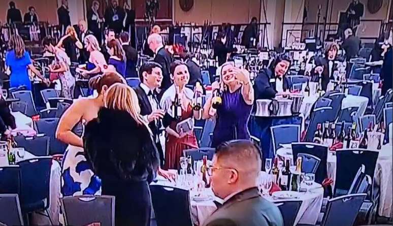 Mulher leva garrafas em jantar com jornalistas nos Estados Unidos, onde ocorreu tiroteio em que Trump estava