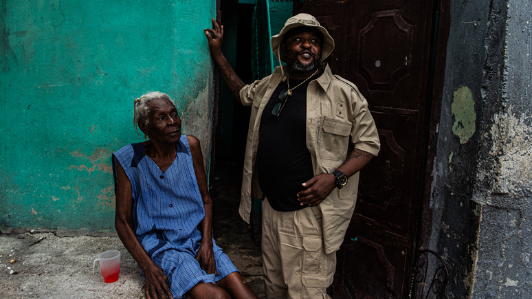 O l&iacute;der de gangue Jimmy Ch&eacute;rizier, conhecido como Barbecue, ao lado de uma moradora de uma regi&atilde;o de Porto Pr&iacute;ncipe controlada por ele, no dia 6 de julho de 2026