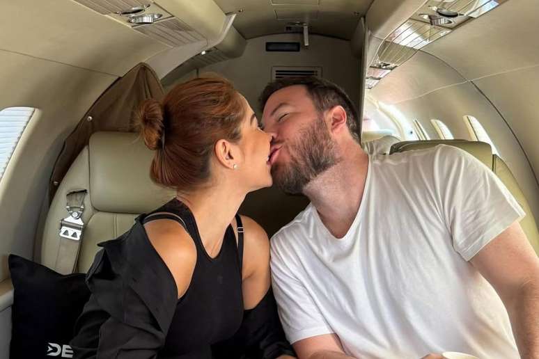 Ma&iacute;ra Cardi beija seu marido, Thiago Nigro, em jatinho