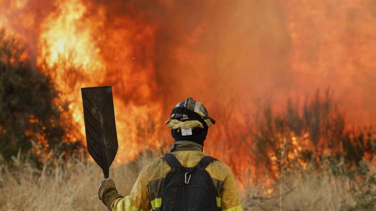 Bombeiro tenta conter o fogo na floresta de Veiga das Meas, na Espanha, em 16 de agosto de 2025.