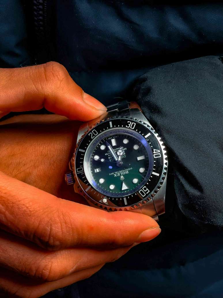 um close-up de uma pessoa ajustando seu rel&oacute;gio Rolex no pulso