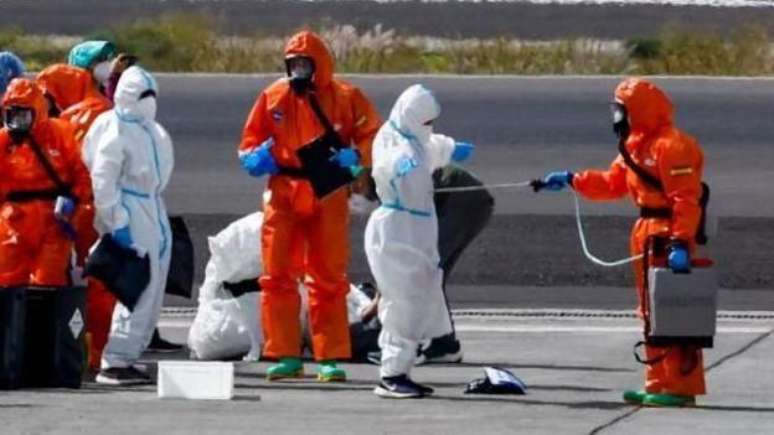 Os passageiros vestiram trajes de prote&ccedil;&atilde;o e foram lavados com mangueiras antes de embarcarem em um avi&atilde;o em Tenerife, ap&oacute;s serem evacuados do navio