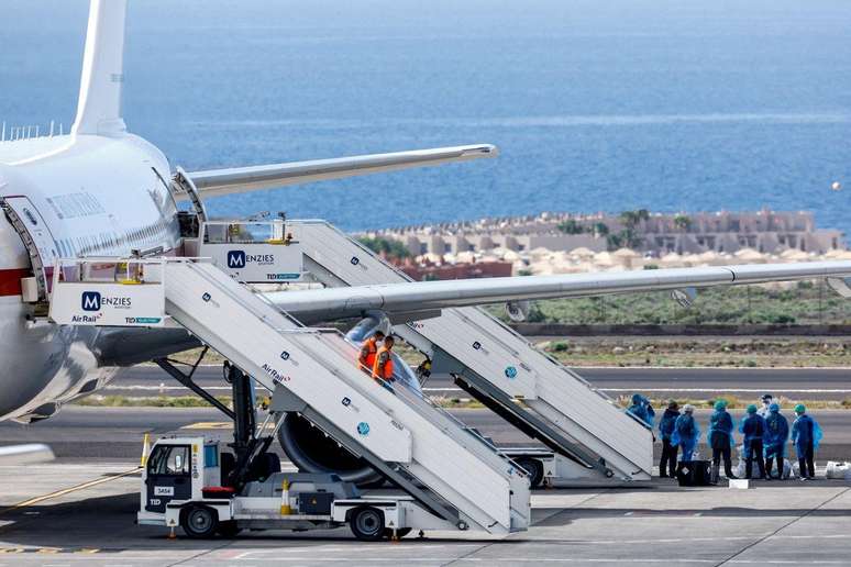 Passageiros do navio de cruzeiro MV Hondius aguardam na pista do aeroporto de Tenerife Sul, em Tenerife