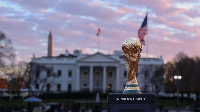 O trof&eacute;u da Copa do Mundo em frente &agrave; Casa Branca, ao lado de bandeiras dos Estados Unidos e com o Monumento a Washington ao fundo