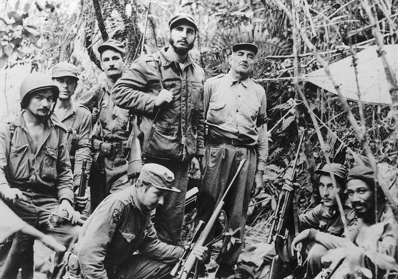 Ra&uacute;l Castro (ao centro, agachado) junto ao irm&atilde;o Fidel e outros guerrilheiros que derrubaram o regime de Batista