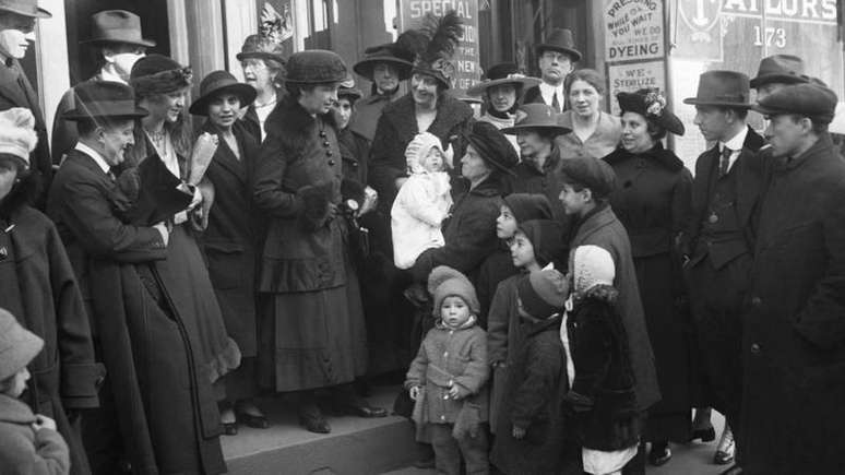 Uma pequena multid&atilde;o se re&uacute;ne em torno de Margaret Sanger e sua irm&atilde;, Ethel Byrne, no tribunal