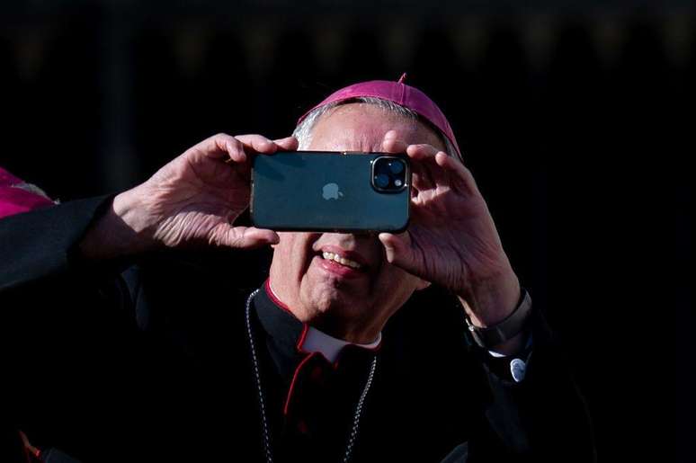 Um bispo tira uma foto com um celular ao final da audi&ecirc;ncia geral semanal do papa Le&atilde;o