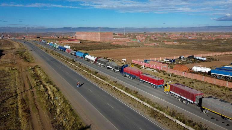Uma fila de caminh&otilde;es aguarda na estrada para poder passar pelos bloqueios