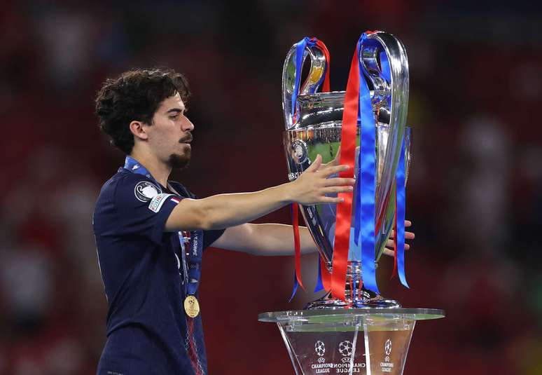 Vitinha celebra conquista do PSG frente a frente com o trof&eacute;u da Champions, em Budapeste &ndash;