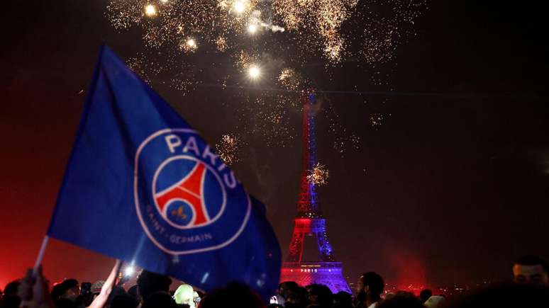 Torcedores do PSG comemoram no Champ de Mars, em frente &agrave; Torre Eiffel, onde o time parisiense &eacute; esperado para a festa da vit&oacute;ria neste domingo. (31/05/2026)