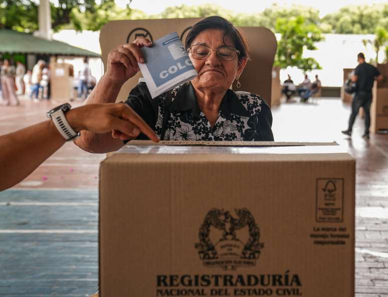 Uma mulher colombiana deposita seu voto na urna. 