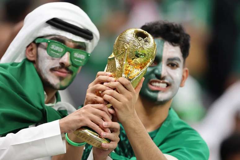 Torcedores da Ar&aacute;bia Saudita com r&eacute;plica do trof&eacute;u da Copa do Mundo 
