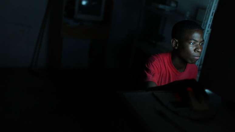 Adolescente usa um computador em lan house na Rocinha, no Rio de Janeiro