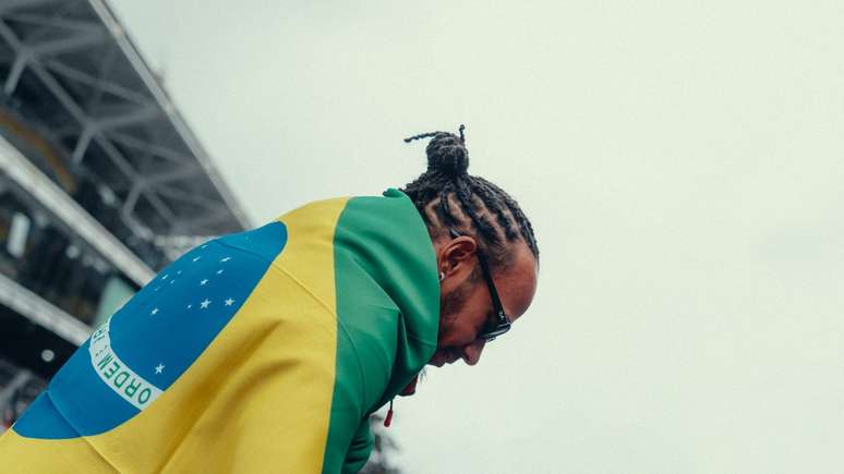 Lewis Hamilton enrolado na bandeira do Brasil 
