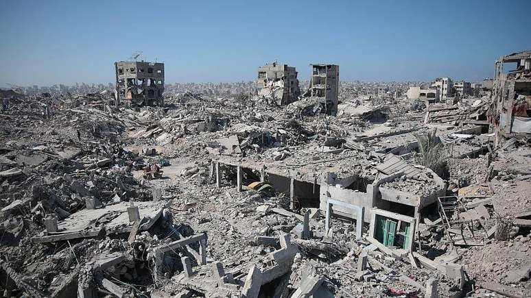 Foto panor&acirc;mica mostrando a devasta&ccedil;&atilde;o em Gaza. Pr&eacute;dios demolidos e escombros s&atilde;o vis&iacute;veis.