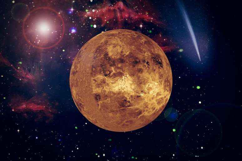 Uma ilustra&ccedil;&atilde;o art&iacute;stica do planeta V&ecirc;nus em destaque no centro, exibindo uma superf&iacute;cie rochosa em tons de dourado e marrom sob uma ilumina&ccedil;&atilde;o lateral. O planeta est&aacute; posicionado contra um fundo c&oacute;smico vibrante, composto por nebulosas avermelhadas, estrelas brilhantes e um cometa com uma cauda longa e luminosa no canto superior direito.