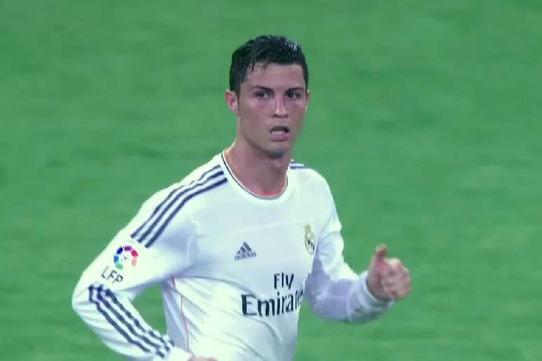 Uma imagem de rosto de Cristiano Ronaldo, um dos melhores jogadores de futebol de todos os tempos, com a camisa branca e azul do Real Madrid, o uniforme n&uacute;mero sete. Ele est&aacute; olhando para a c&acirc;mera com uma express&atilde;o s&eacute;ria. O fundo &eacute; um campo de futebol.