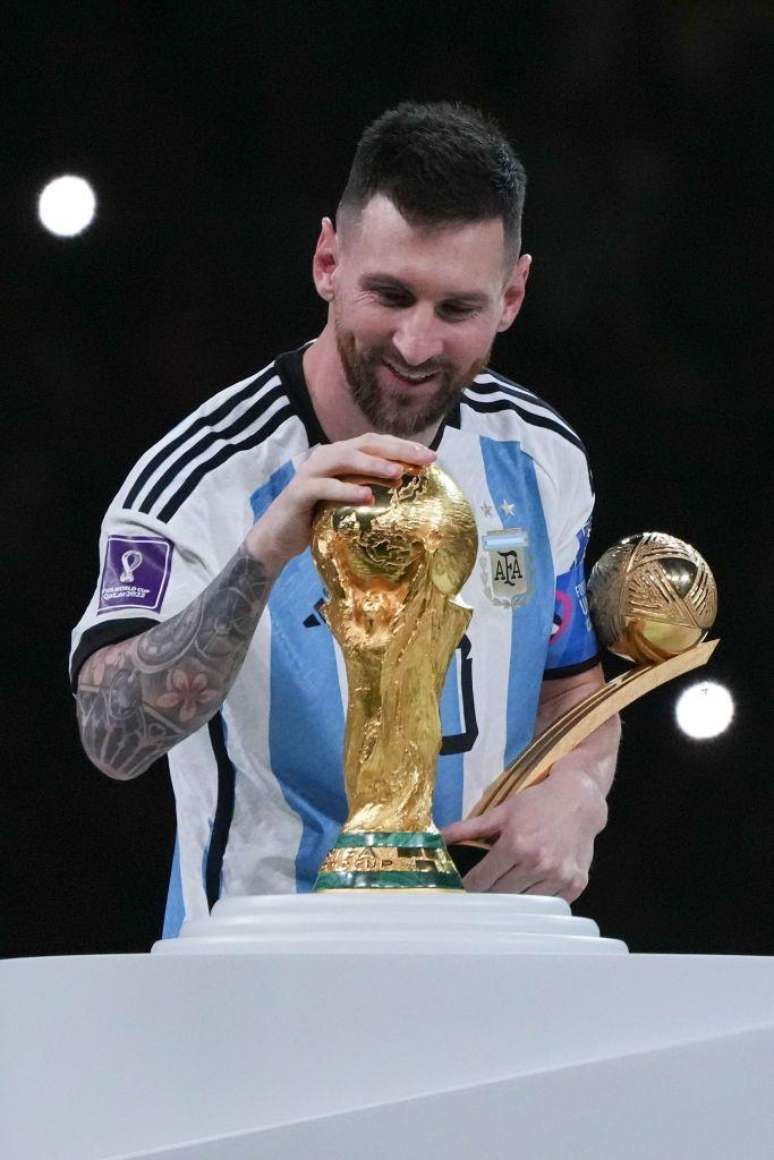 Messi trata com carinho o trof&eacute;u da Copa do Mundo no tricampeonato da Argentina em 2022, no Catar