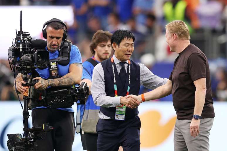 Ronald Koeman cumprimentando Hajime Moriyasu ap&oacute;s o empate com o Jap&atilde;o 