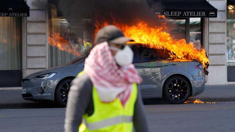 Um carro foi incendiado durante o protesto nas ruas de Genebra em 14 de junho de 2026 realizado contra a reuni&atilde;o de c&uacute;pula do G7, que come&ccedil;a no dia seguinte em Evian.