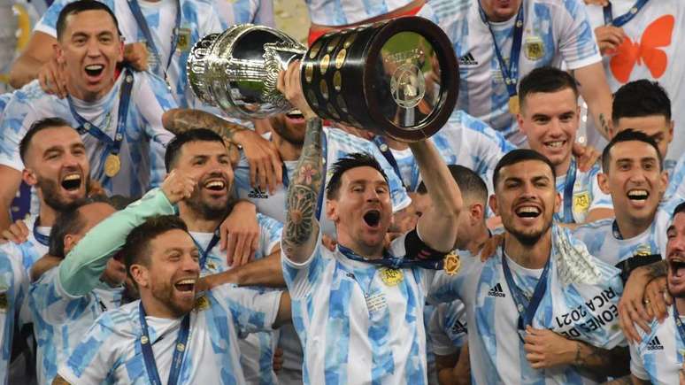 Messi levanta o trof&eacute;u da Copa Am&eacute;rica em meio aos seus companheiros, ap&oacute;s a vit&oacute;ria da Argentina no torneio de 2021