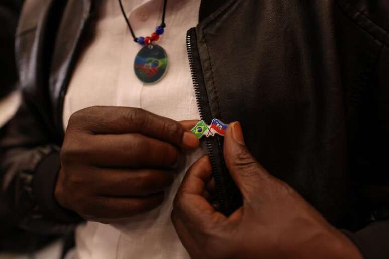 Haitiano mostra adere&ccedil;o com as bandeiras dos dois pa&iacute;ses na Igreja Nossa Senhora da Paz, no bairro do Glic&eacute;rio