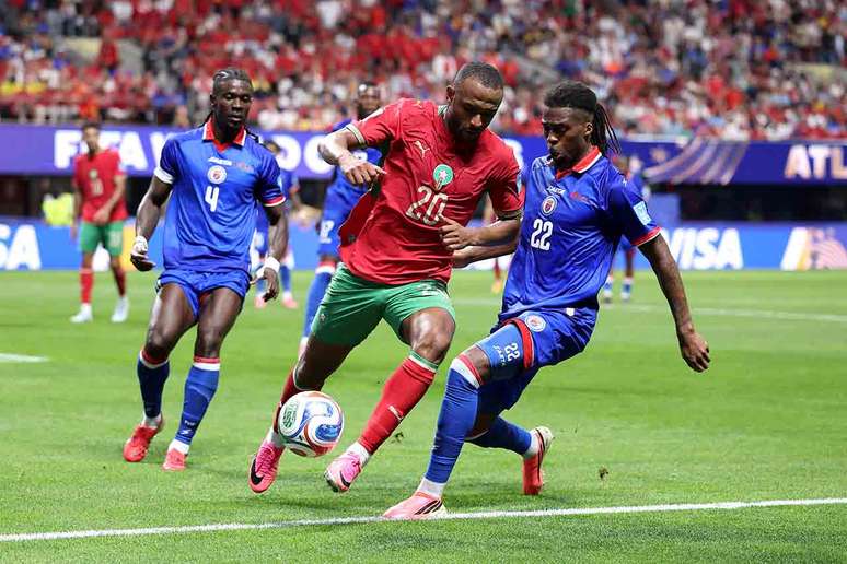 El Kaabi (de vermelho) recebe a marca&ccedil;&atilde;o de Duverne, do Haiti.