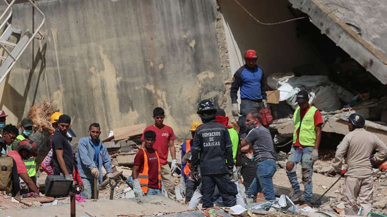 Moradores de La Guaira procuram sobreviventes com as próprias mãos após os terremotos que atingiram a Venezuela.