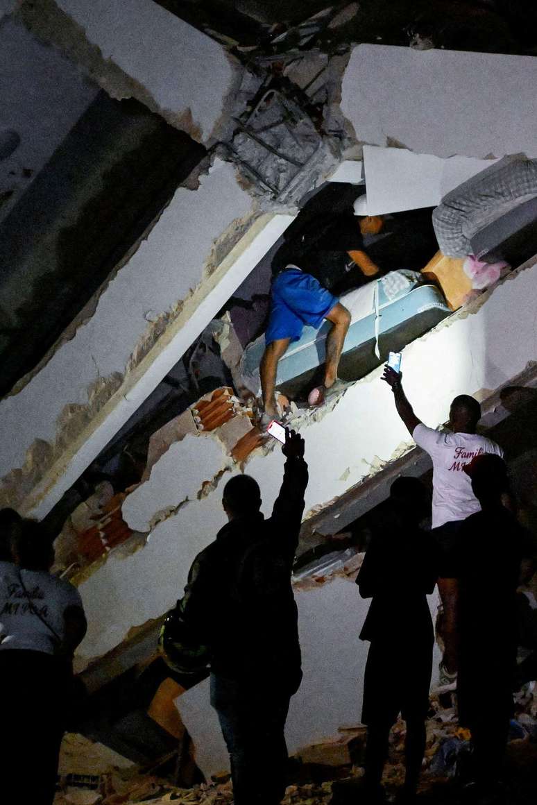 Apesar do perigo de se aproximar dos escombros, muitos tentavam resgatar sobreviventes em La Guaira durante a madrugada de quinta
