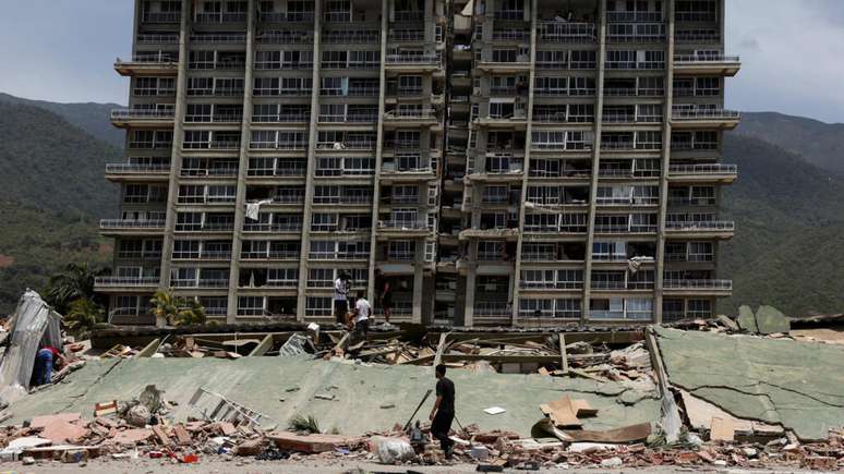 Moradores de La Guaira vasculham os escombros de um pr&eacute;dio que desabou ap&oacute;s o duplo terremoto de quarta-feira (24). Venezuela, 25 de junho de 2026.