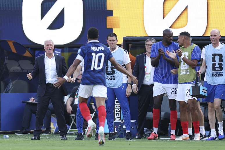 Mbapp&eacute; indo abran&ccedil;ar o t&eacute;cnico Didier Deschamps 