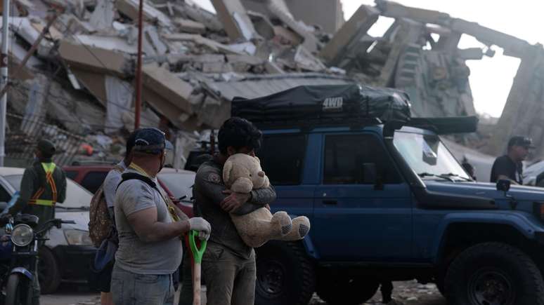 Familiares dos migrantes que foram deportados no voo 164, que chegou &agrave; Venezuela no dia dos dois terremotos (24/6), no lado de fora dos edif&iacute;cios que desabaram em La Guaira