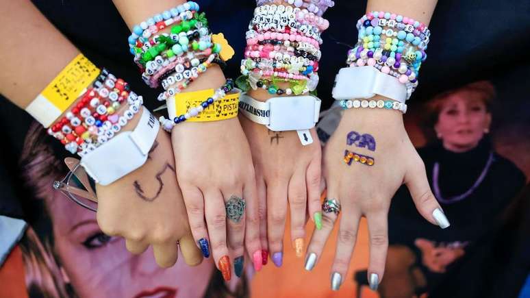 F&atilde;s exibem pulseiras que fizeram &agrave; m&atilde;o em homenagem a Taylor Swift no Allianz Parque, em S&atilde;o Paulo