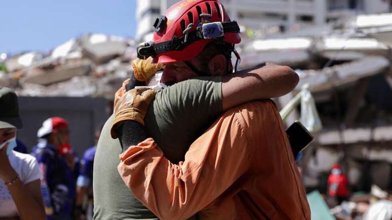 Um homem abra&ccedil;a um membro da equipe da Argentina que o ajudou a resgatar sua irm&atilde; ap&oacute;s os terremotos de 24 de junho, em La Guaira, Venezuela, em 6 de julho de 2026.