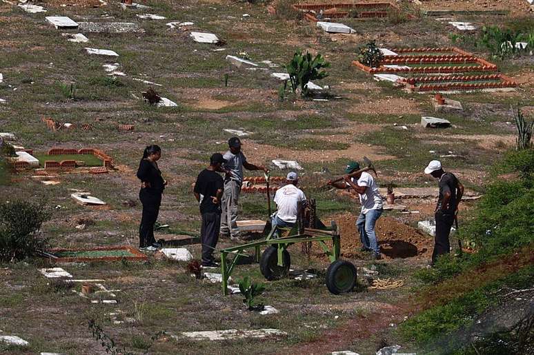 Trabalhadores abrem algumas das valas para enterrar os corpos que foram levados nos &uacute;ltimos dias ao cemit&eacute;rio La Esperanza