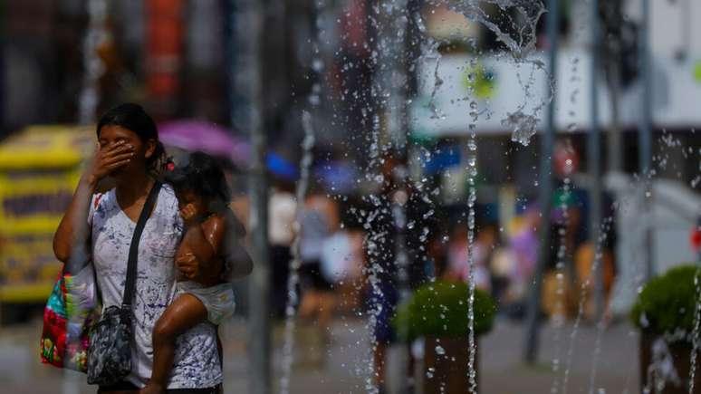 Extenso, Brasil sofre com dezenas de ondas de calor ao longo do ano. Na imagem, mulher se refresca em chafariz de Porto Alegre. (15/12/2023)