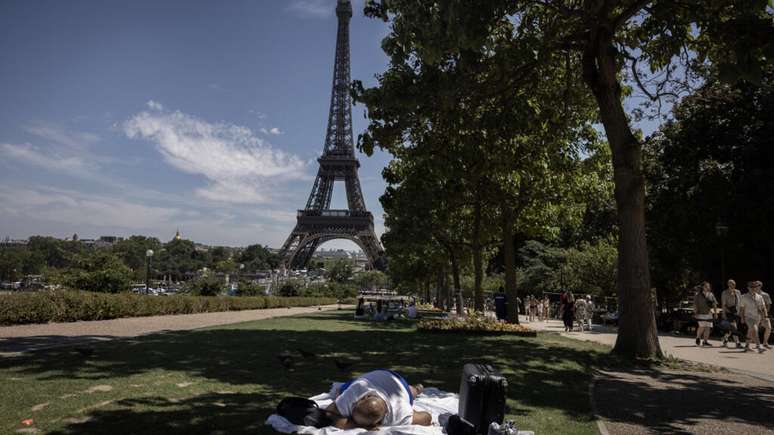 Homem descansa &agrave; sombra de uma &aacute;rvore pr&oacute;ximo &agrave; Torre Eiffel durante nova onda de calor que atinge a Fran&ccedil;a, em 10 de julho de 2026.