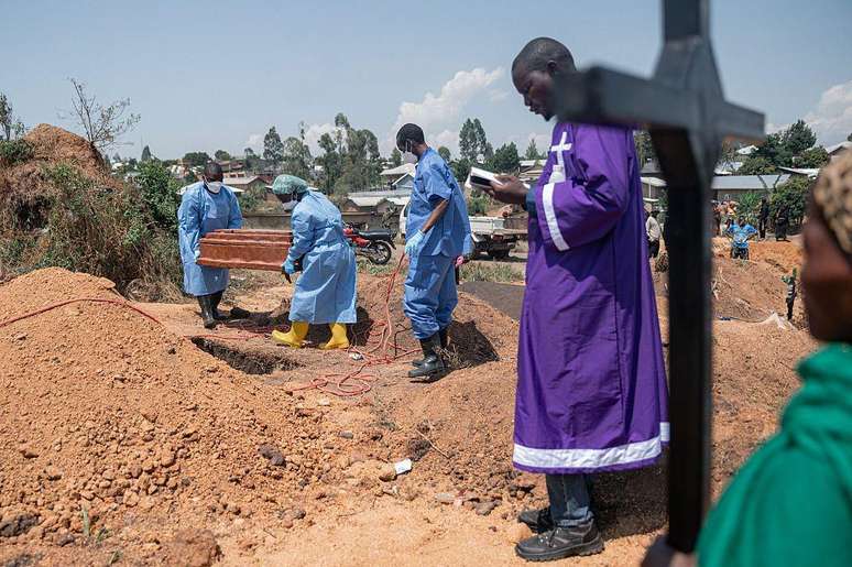 Um sacerdote realiza uma cerim&ocirc;nia de b&ecirc;n&ccedil;&atilde;o no cemit&eacute;rio de Mbiyo para um &oacute;rf&atilde;o que morreu de Ebola em Bunia