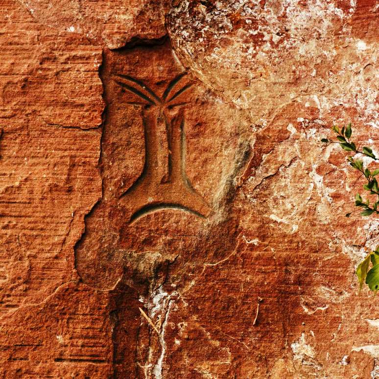 rocha alaranjada com arte rupestre antiga pintada